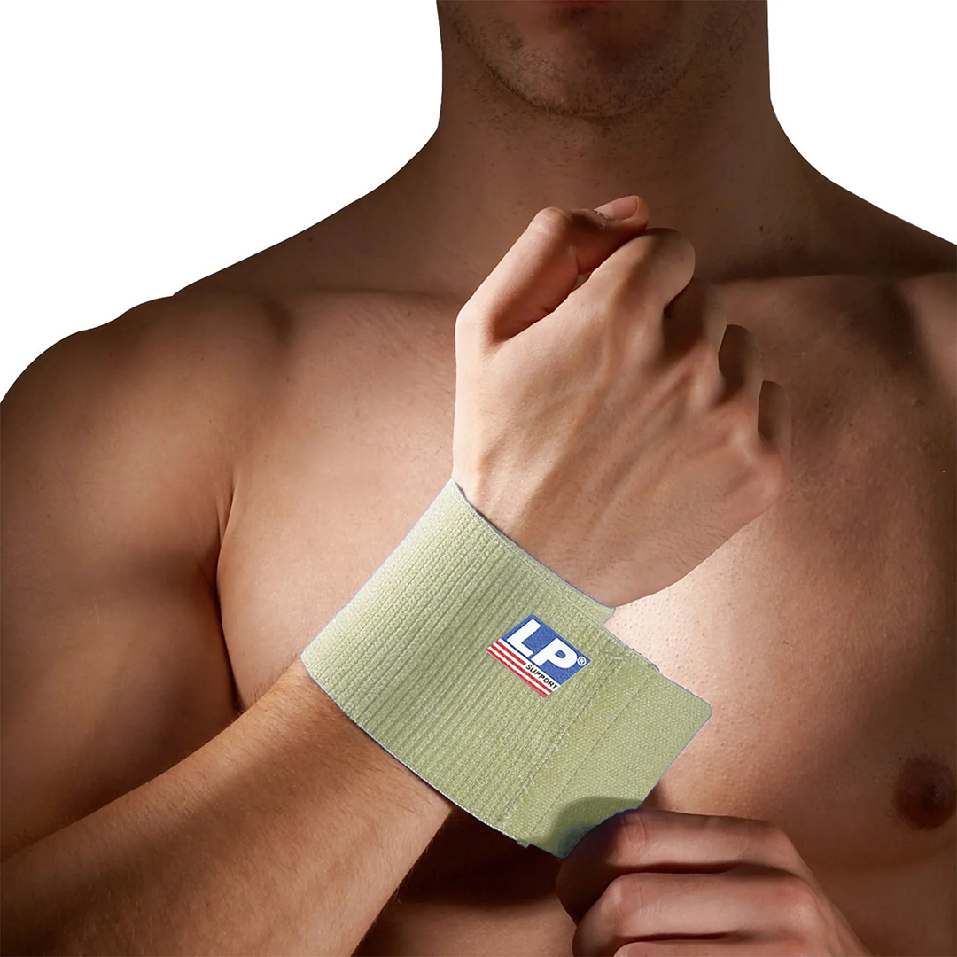 Man wearing a tan wrist support brace with a brand logo on a white background