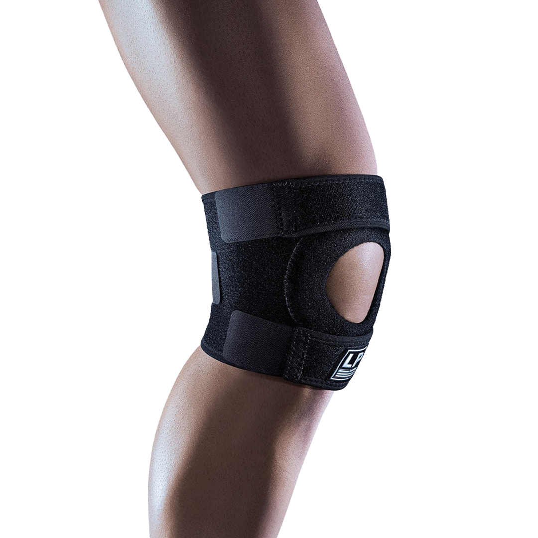 Black knee brace on a person&#39;s knee with a white background