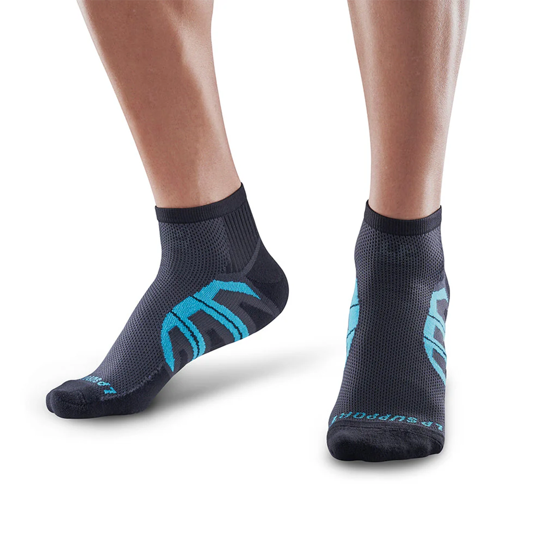 Black socks with cyan accents worn by a person on a white background